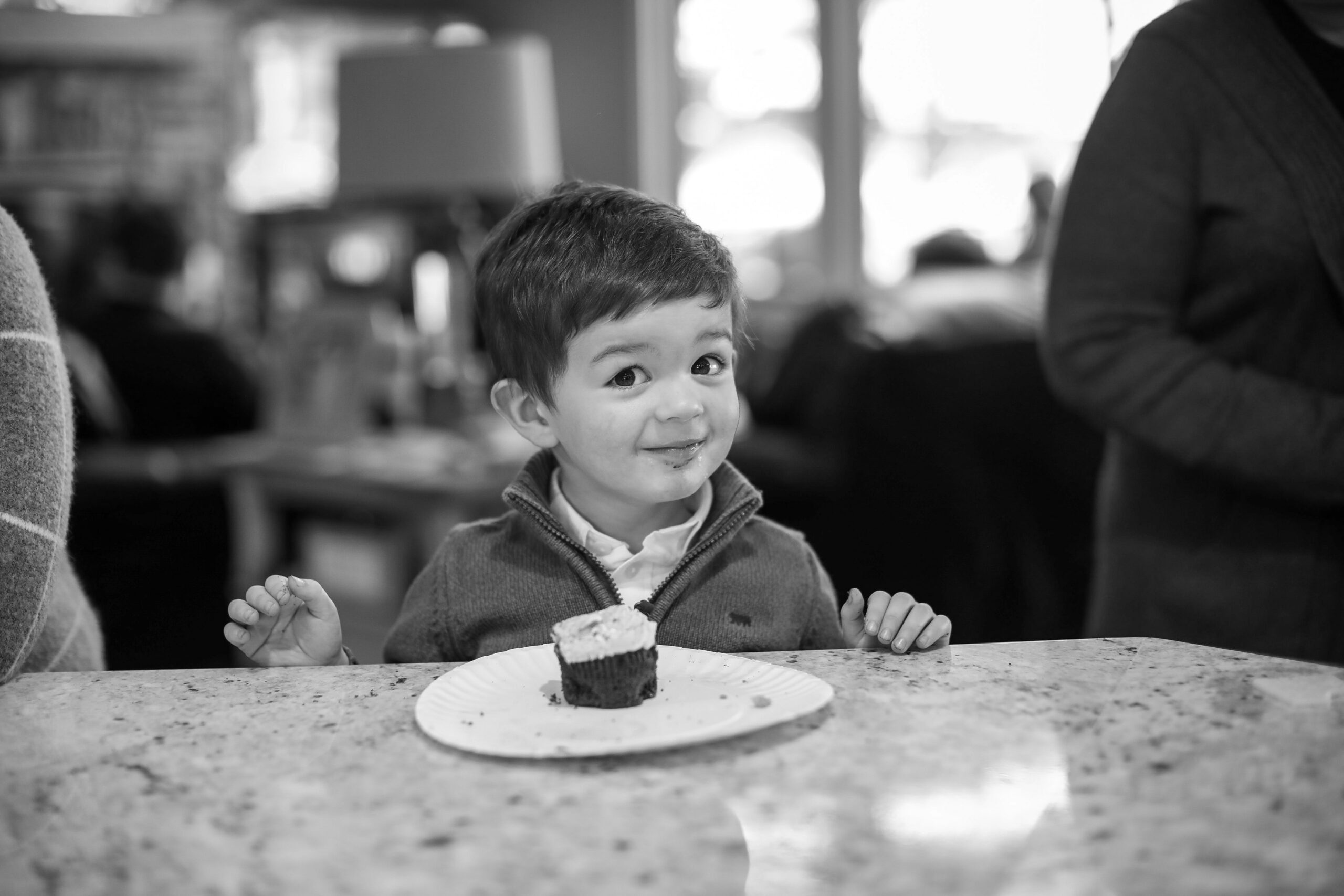 Un jeune enfant assis à un comptoir, joyeux et surpris, découvrant avec plaisir le bénéfice caché de manger au restaurant.